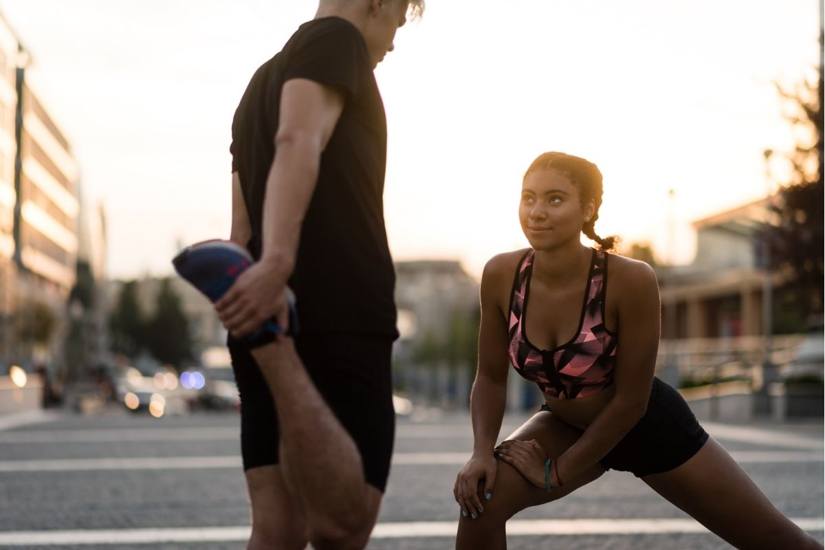 A young woman and man stretching after exercise