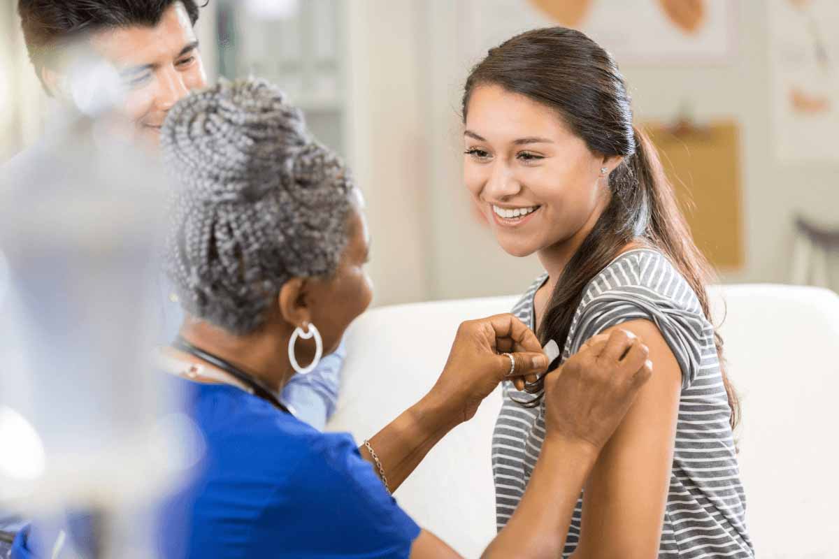 A woman receiving the flu vaccine from a healthcare worker 