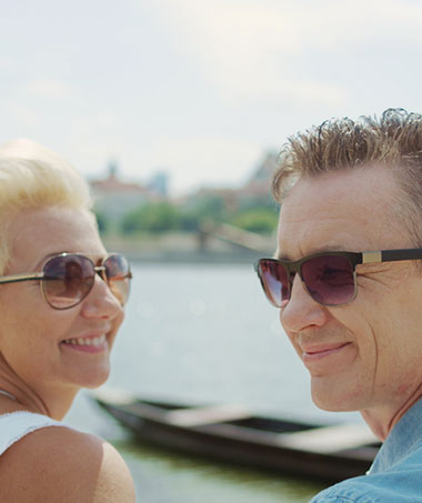 A couple wearing sunglasses to slow down the progression of developing cataracts