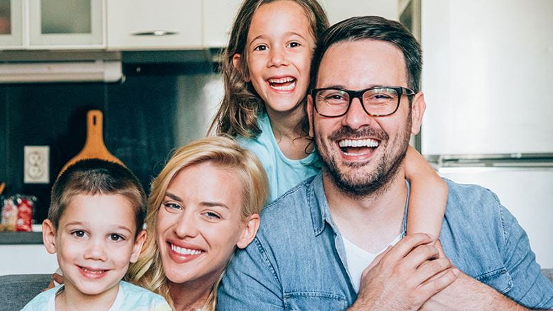 Family smiling on couch