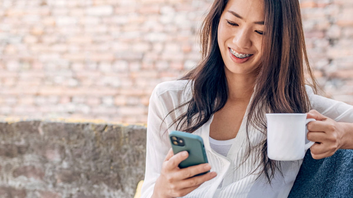 Woman having coffee on her phone