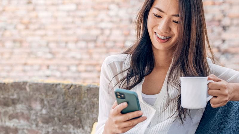 Woman having coffee on her phone