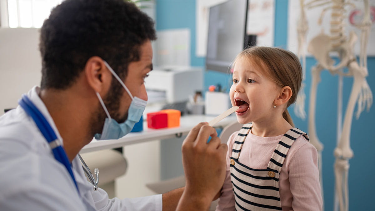 Doctor checking child tonsils