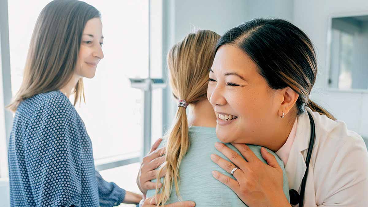 Doctor hugging young patient