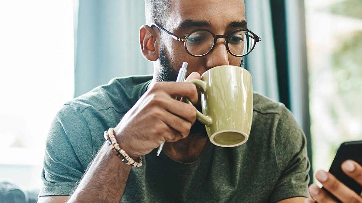 Young man drinking a coffee on his phone
