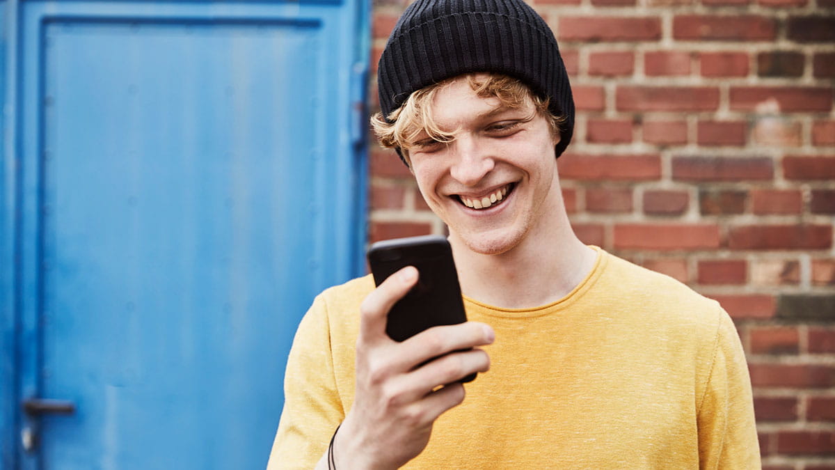 Man with beanie looking at his phone