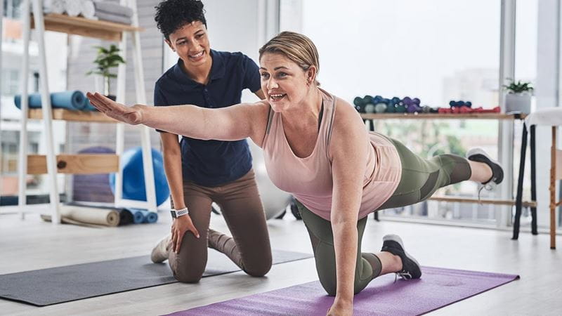 Woman with physiotherapist doing pilates