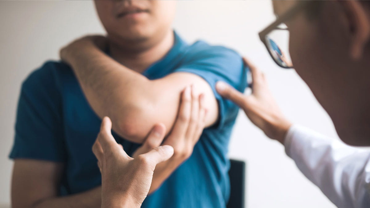 Doctor looking at mans elbow