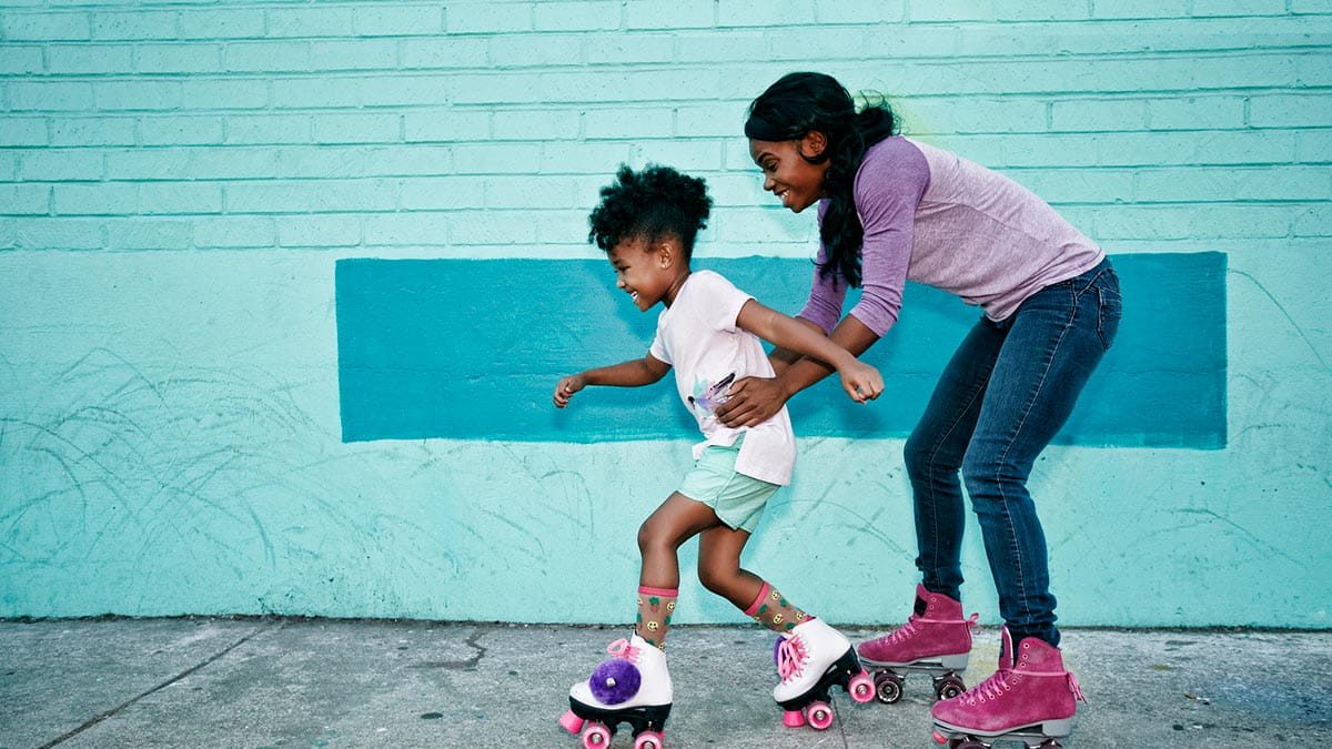 Mother with young daughter rollerskating