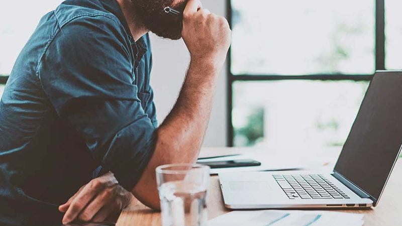 Man thinking on laptop
