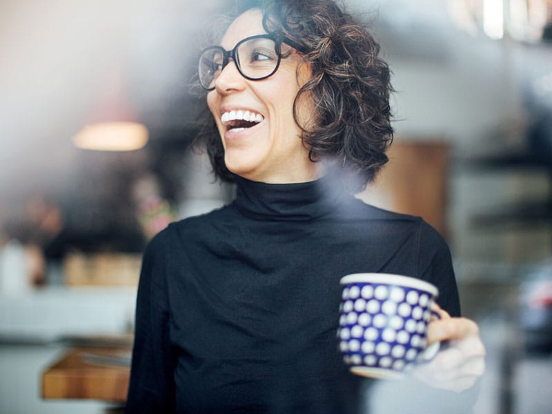 Corporate woman smiling with a cup of tea