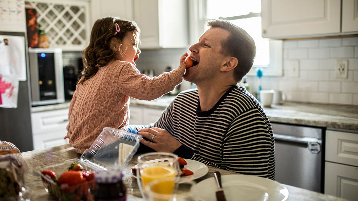 Daughter feeding her father strawberries