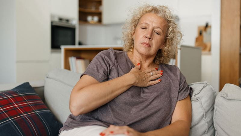 A woman with indigestion holding her hand to her chest