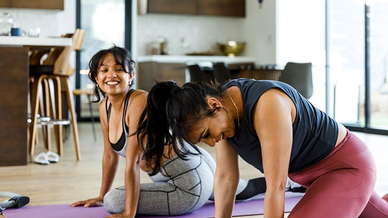 Two women stretching their lower backs