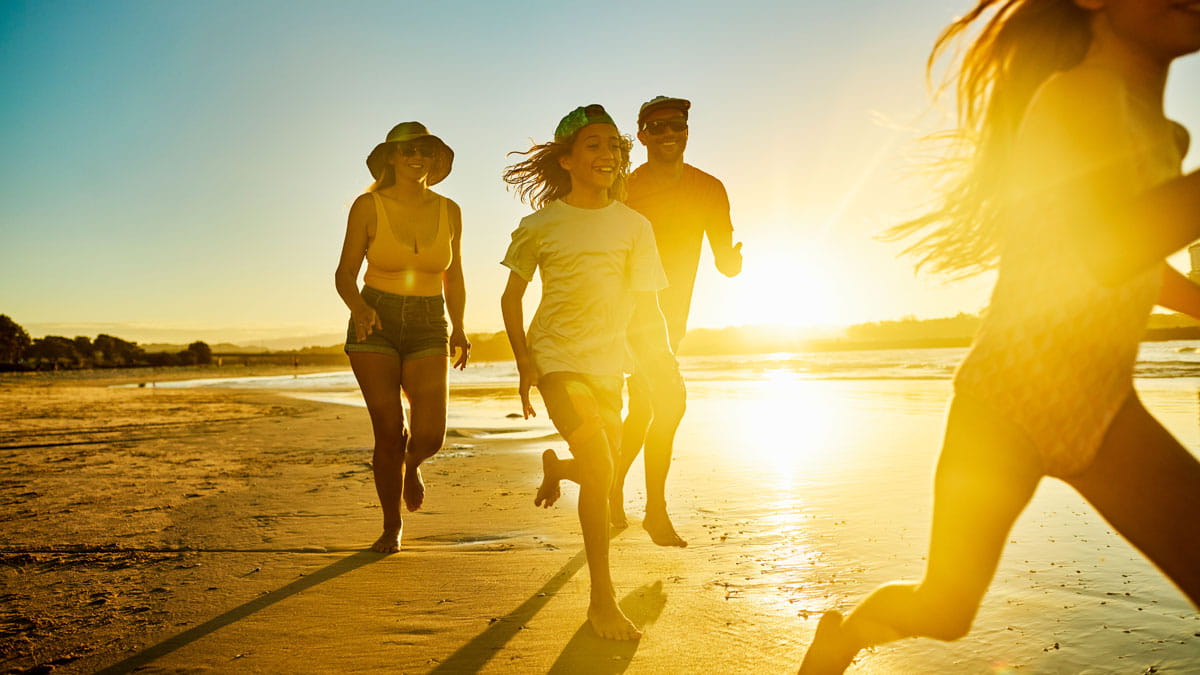 Family running along the beach