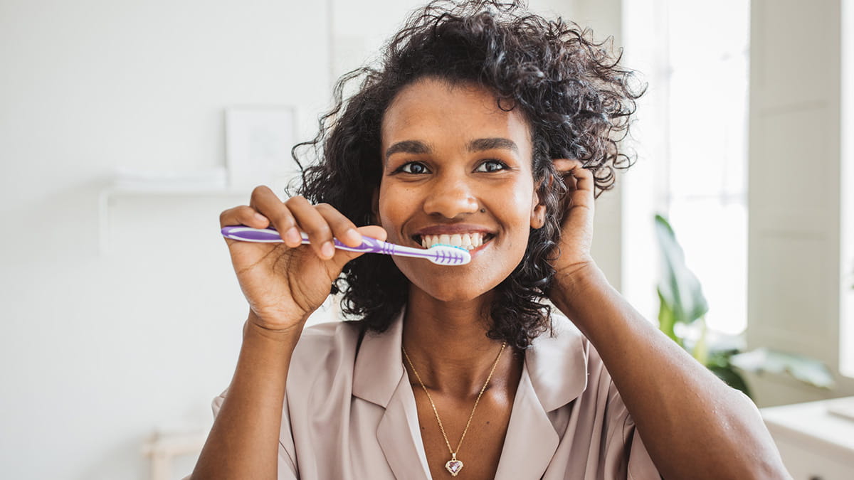 Girl brushing her teeth and smiling