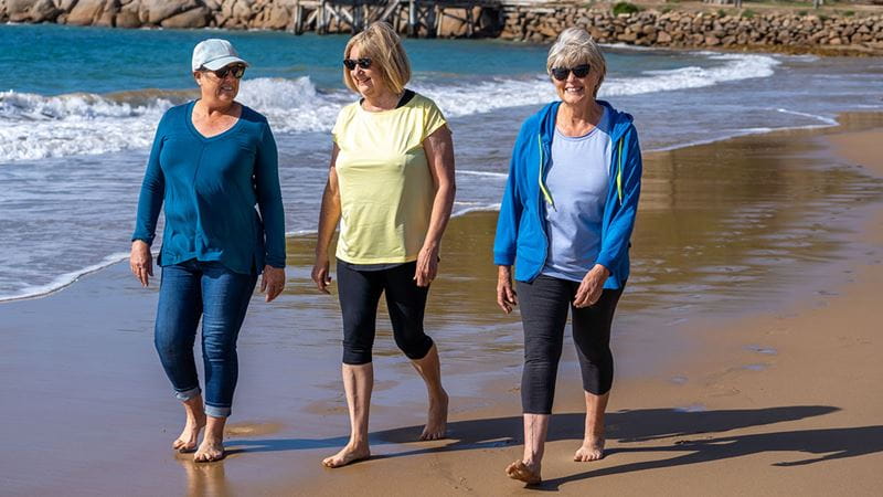 Thee ladies walking along the beach