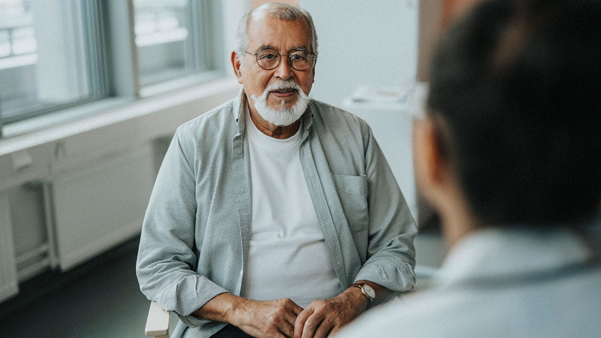 Elderly man speaking to doctor