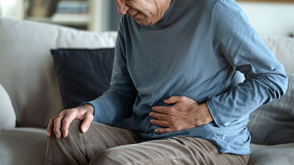 Older man clutching stomach