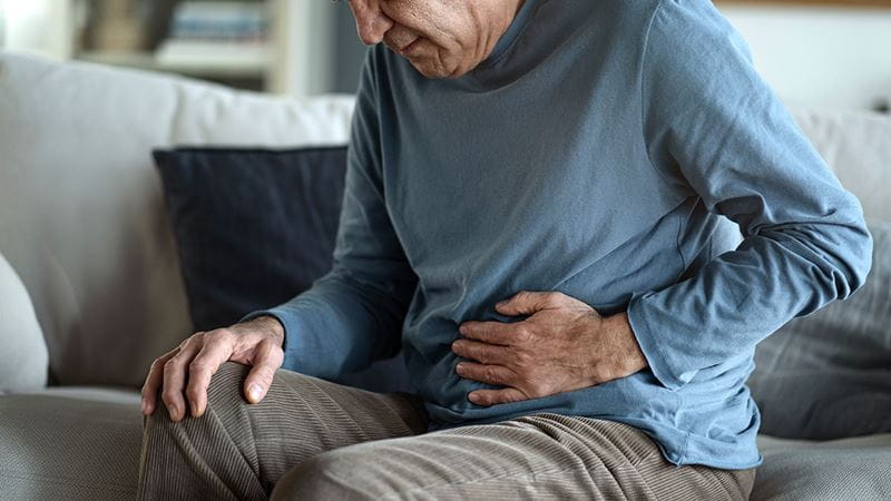 Older man clutching stomach