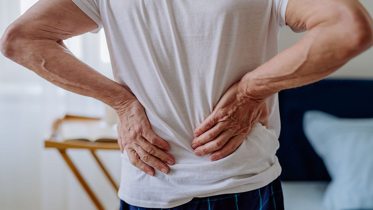 Man holding lower back in pain