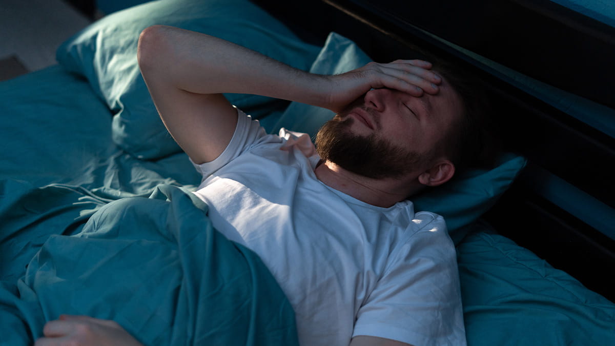 Man in bed trying to sleep