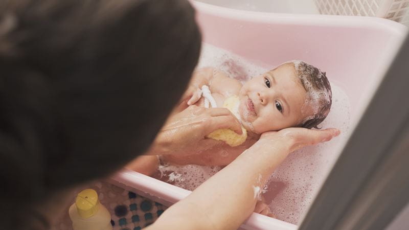Washing a baby in a bath