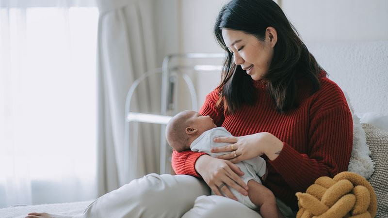 Woman holding her baby looking for cues