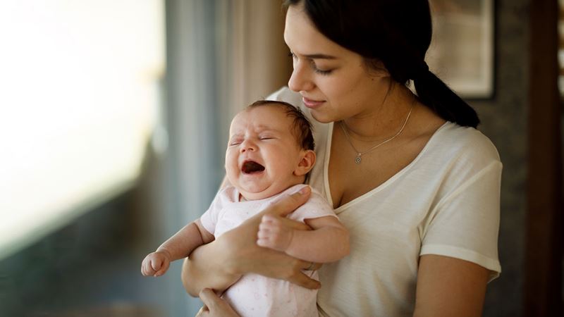 Woman holding her crying baby