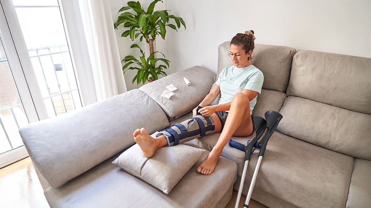 Woman sitting on couch with leg in cast