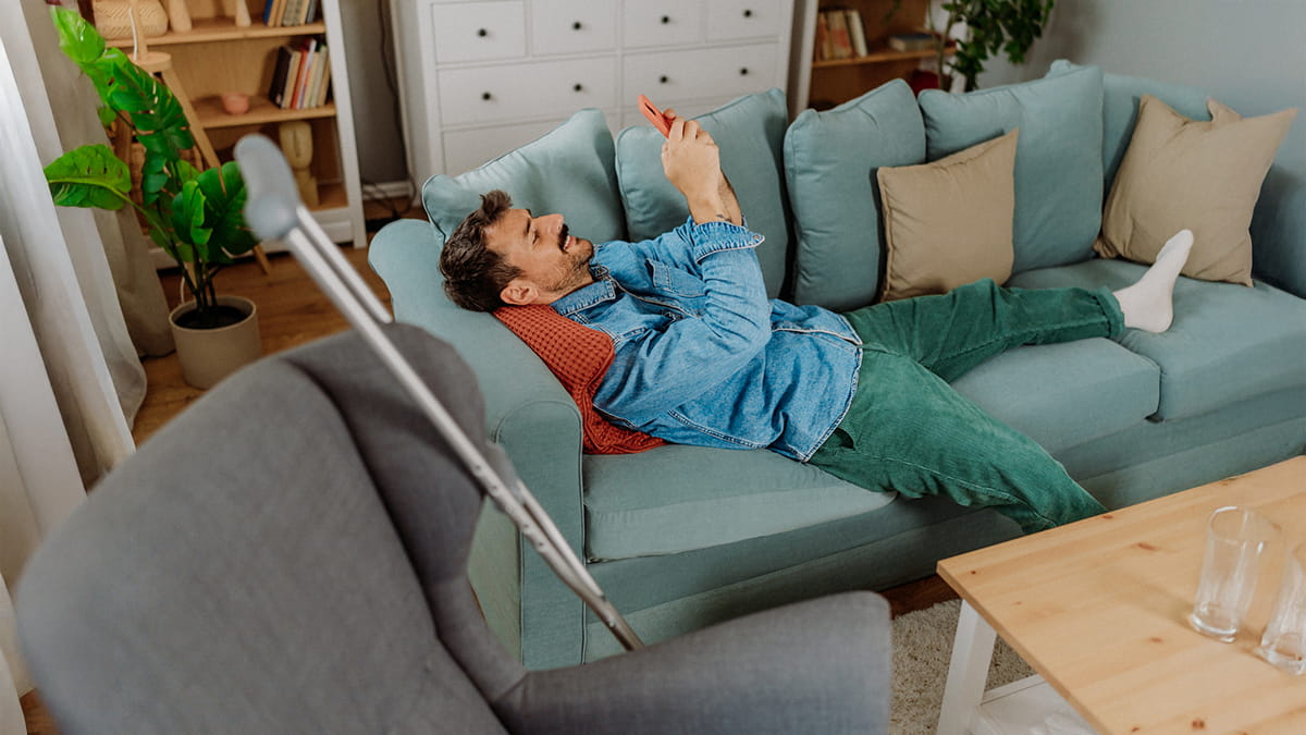 Man on his phone lying on a couch