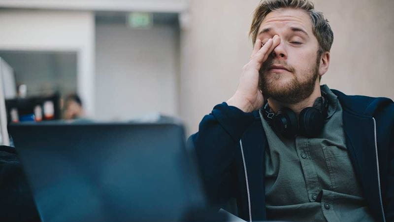 A man at work tired because he is struggling with sleep apnoea