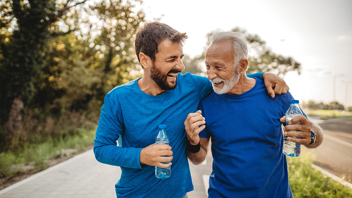 Adult father and son laughing while walking together