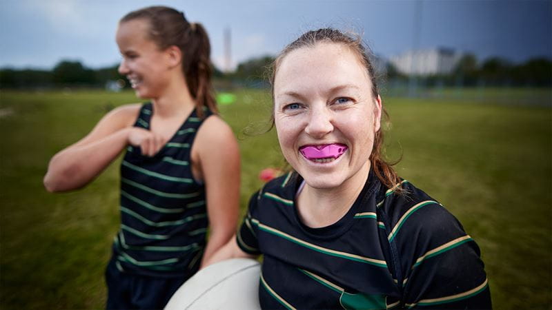 Young girl smiling and showing off her mouth guard