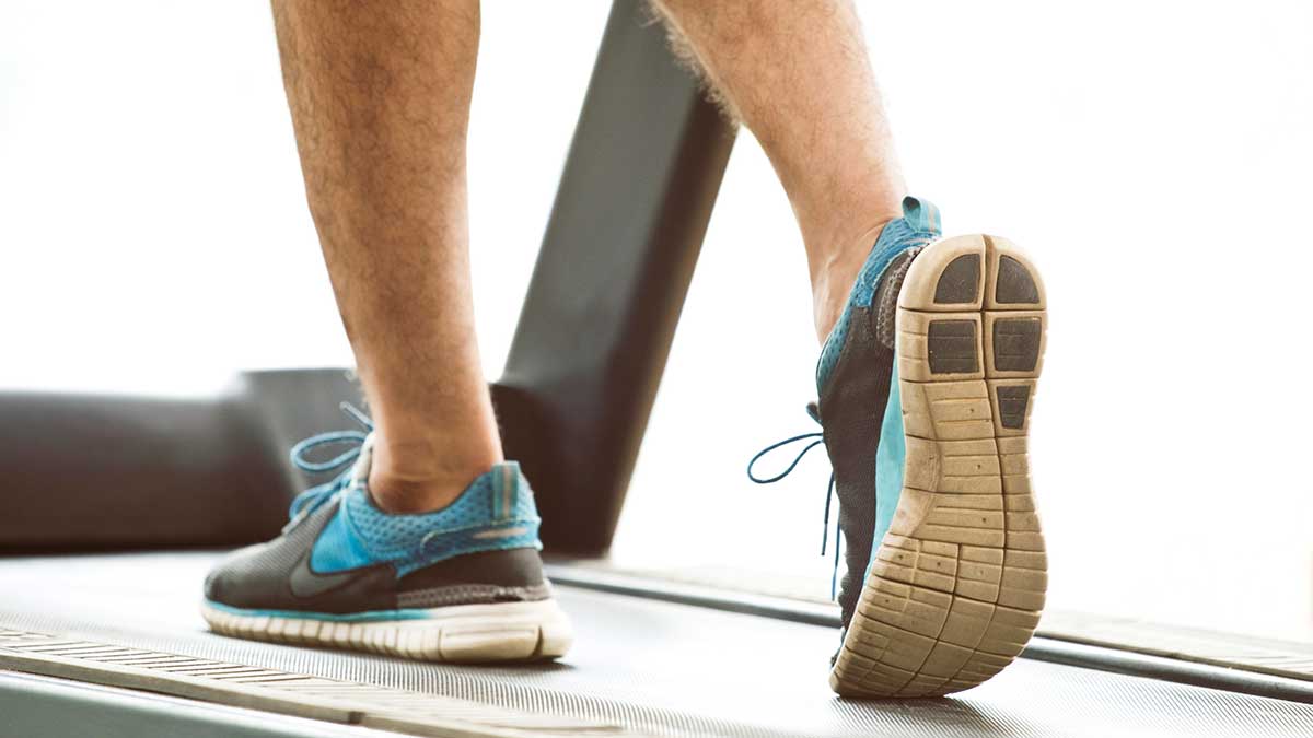lower legs of man walking on treadmill