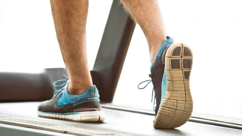 lower legs of man walking on treadmill