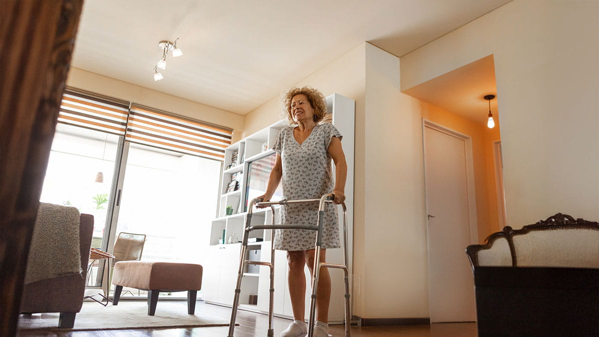 Elderly woman standing with walker