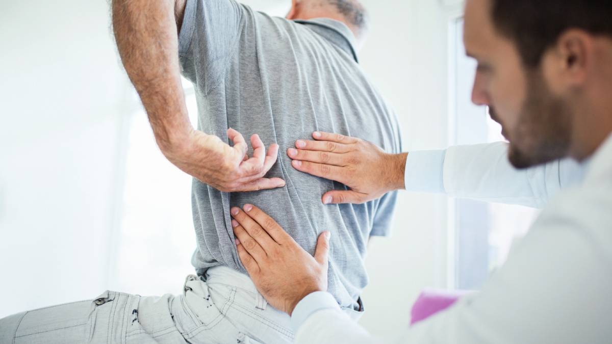 Male physiotherapist assessing his patients back