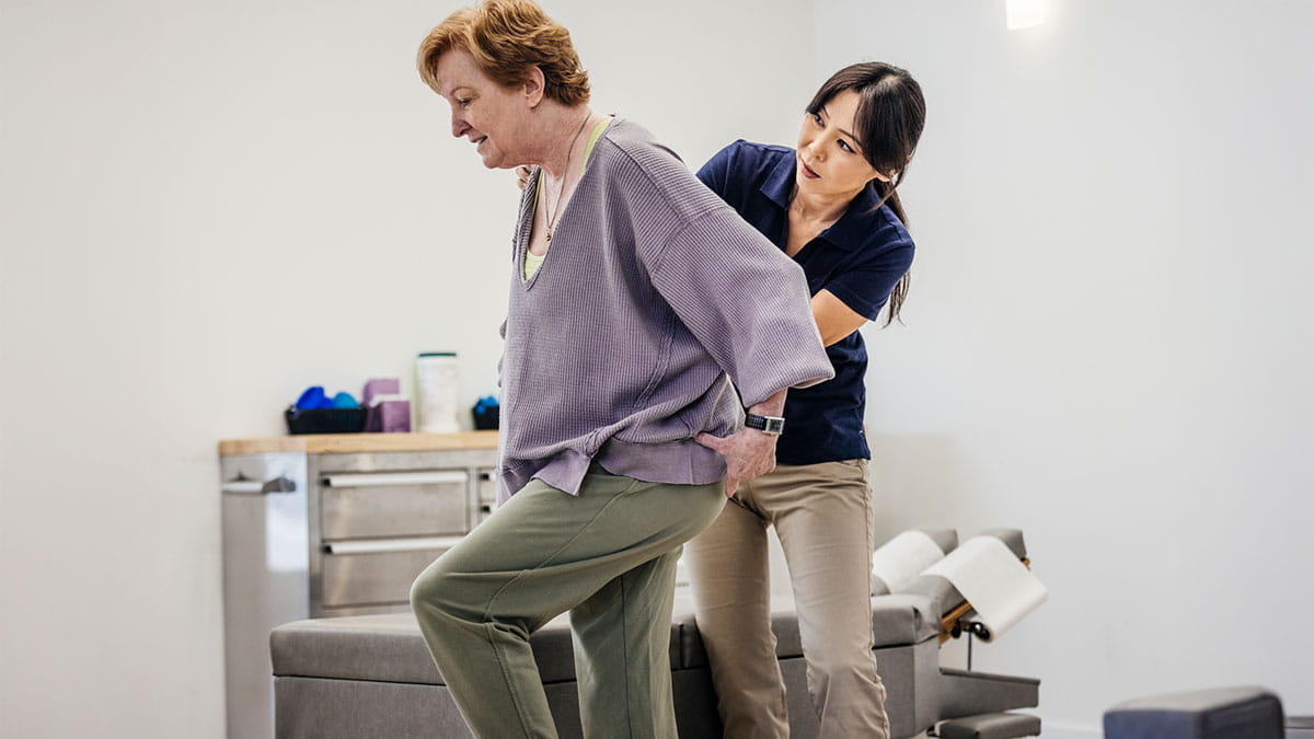 Woman being helped on stroller with nurse
