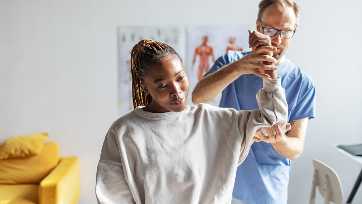 Woman learning shoulder mobility exercises after shoulder surgery