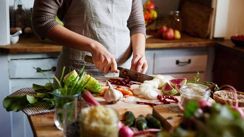 Woman chopping vegetables in kitchen