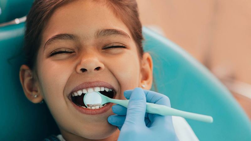 Young girl getting her teeth checked at dentist