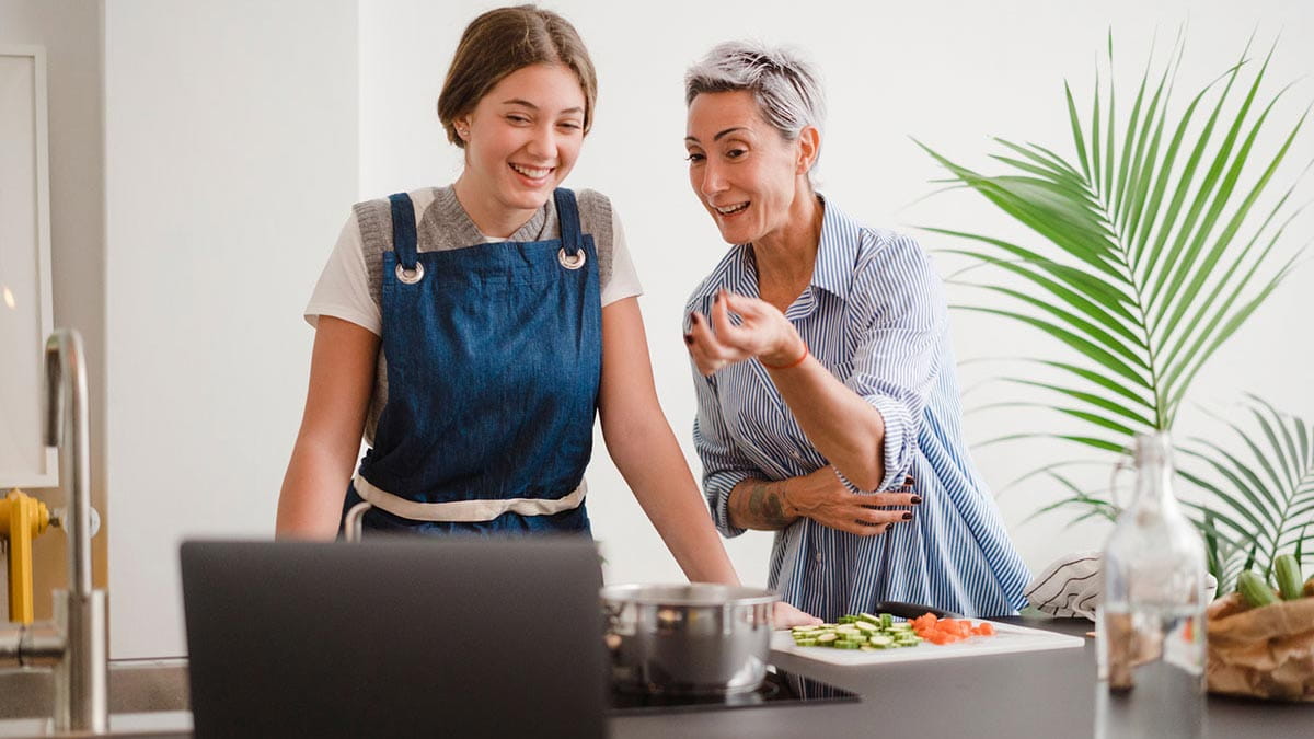 Two people in kitchen with laptop