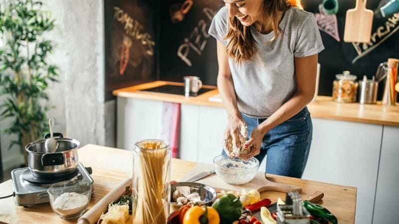 Woman preparing food at a kitchen bench