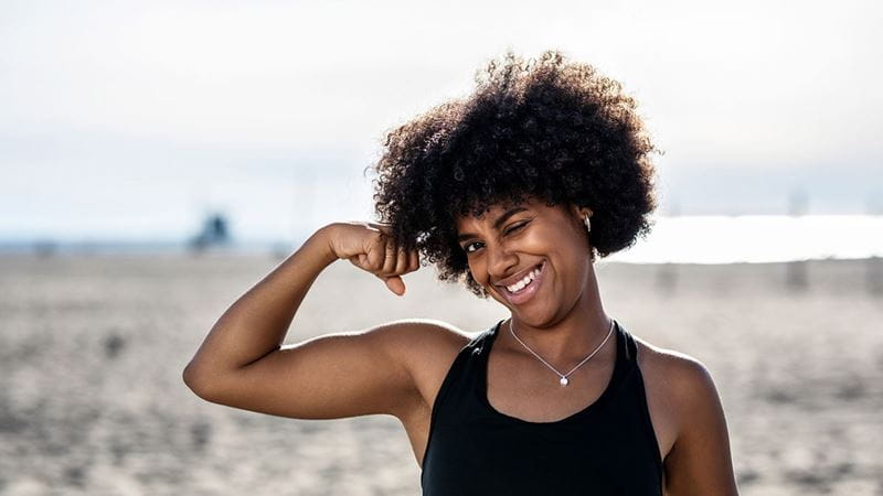 Woman smiling and flexing biceps