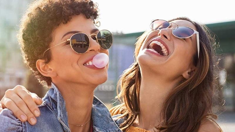 Two young women laughing and having fun at a party.