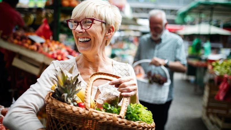 A woman laughs as she shops for health fruit and vegetables