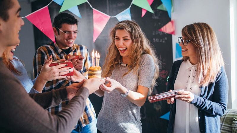 Group of young people celebrating with birthday cake