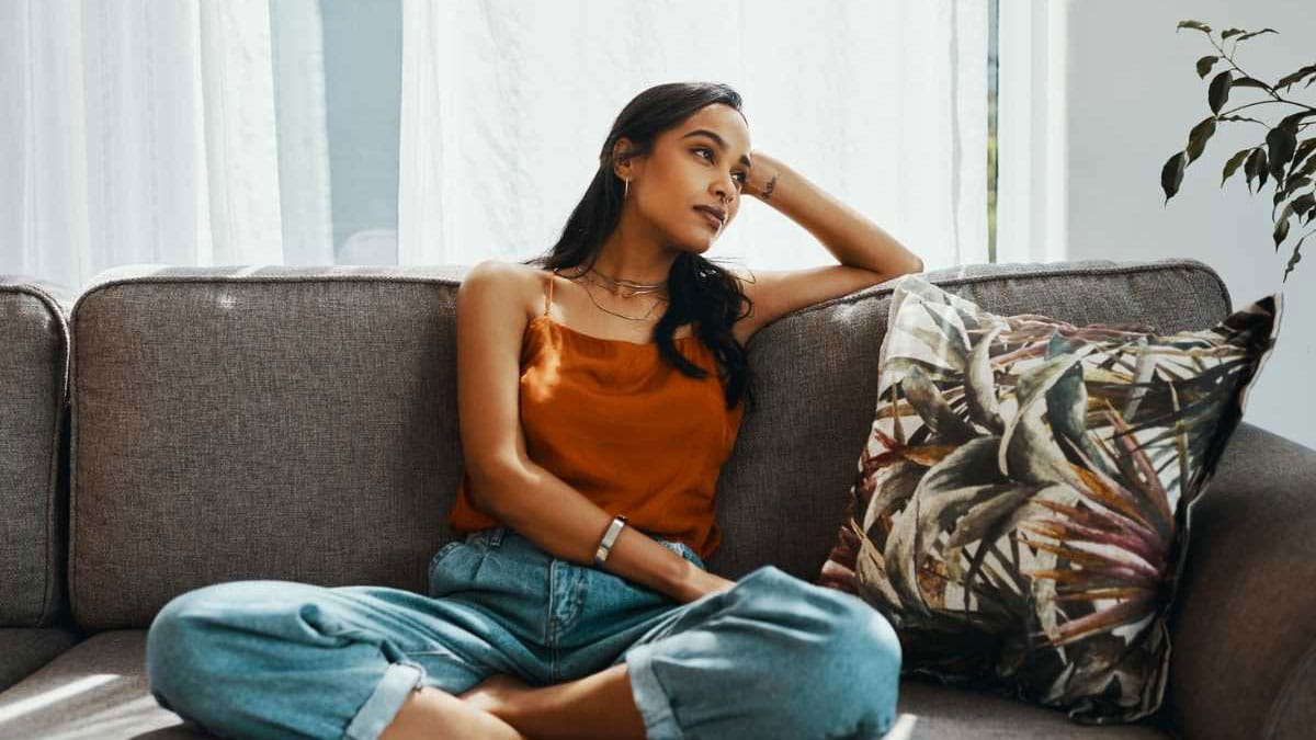 Woman sitting on couch looking sad