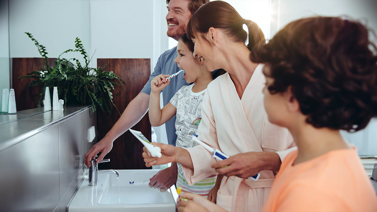 Family brushing teeth together